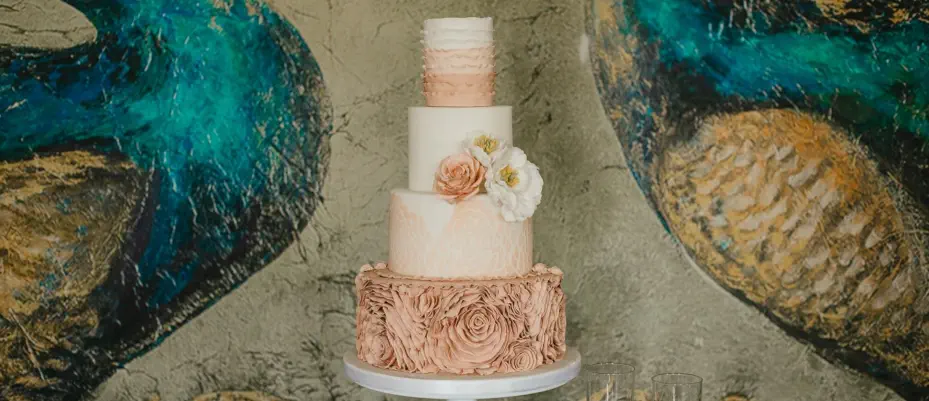 A lavish wedding dessert table adorned with popsicles, fudge, cupcakes, treats, macarons and more